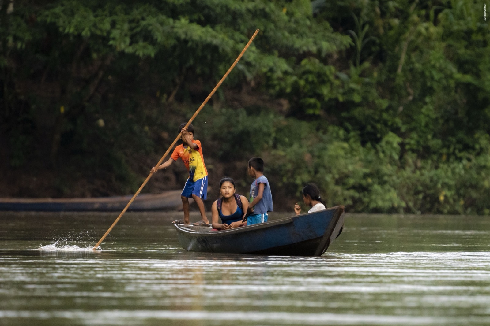 Children navigating river by canoe