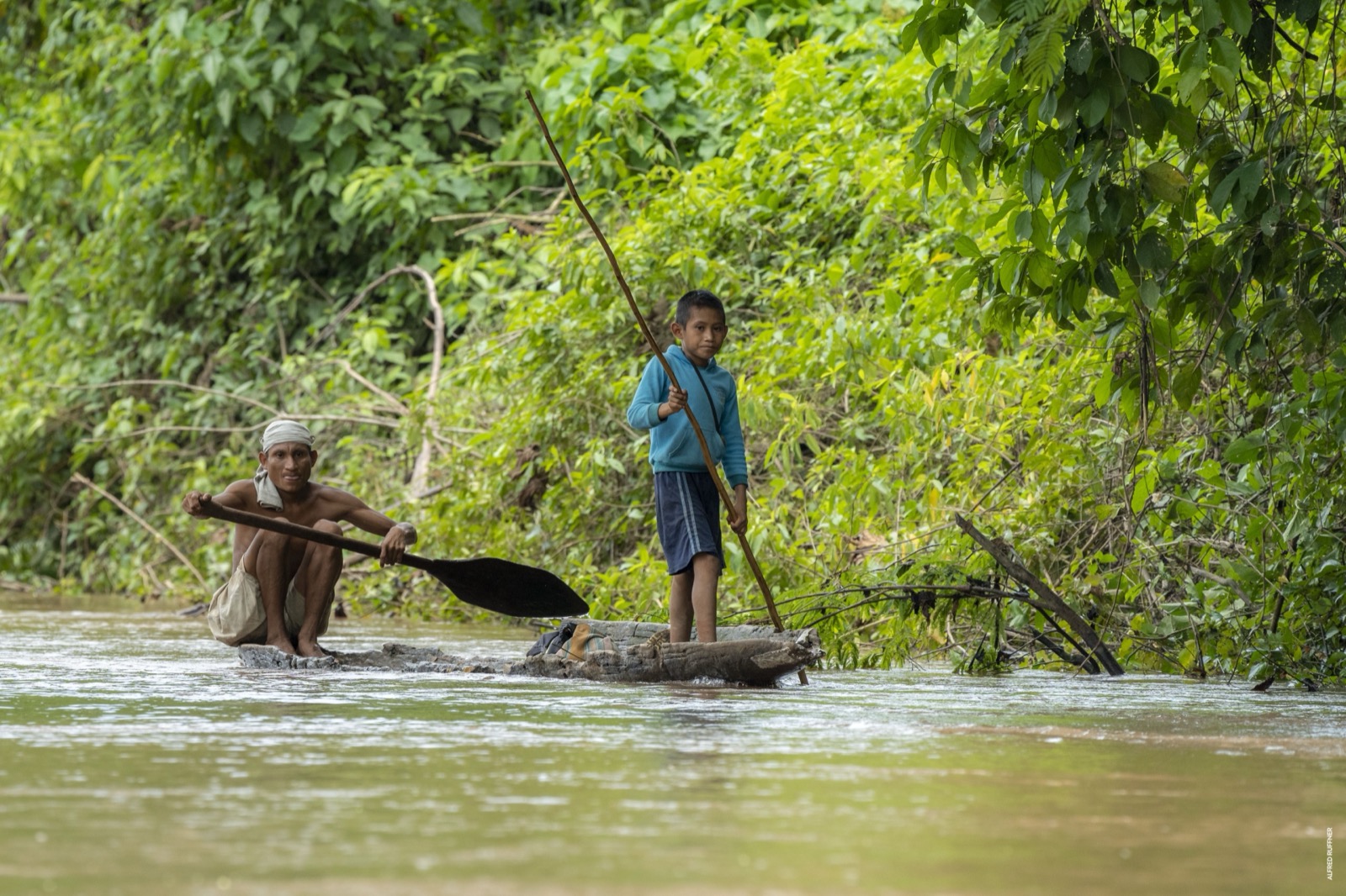 Elder and boy paddling on raft