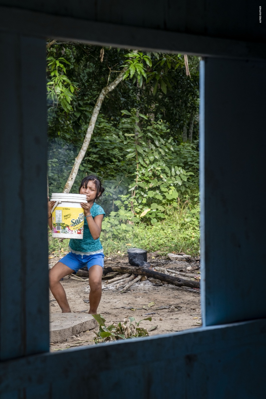 Girl carrying bucket in jungle village