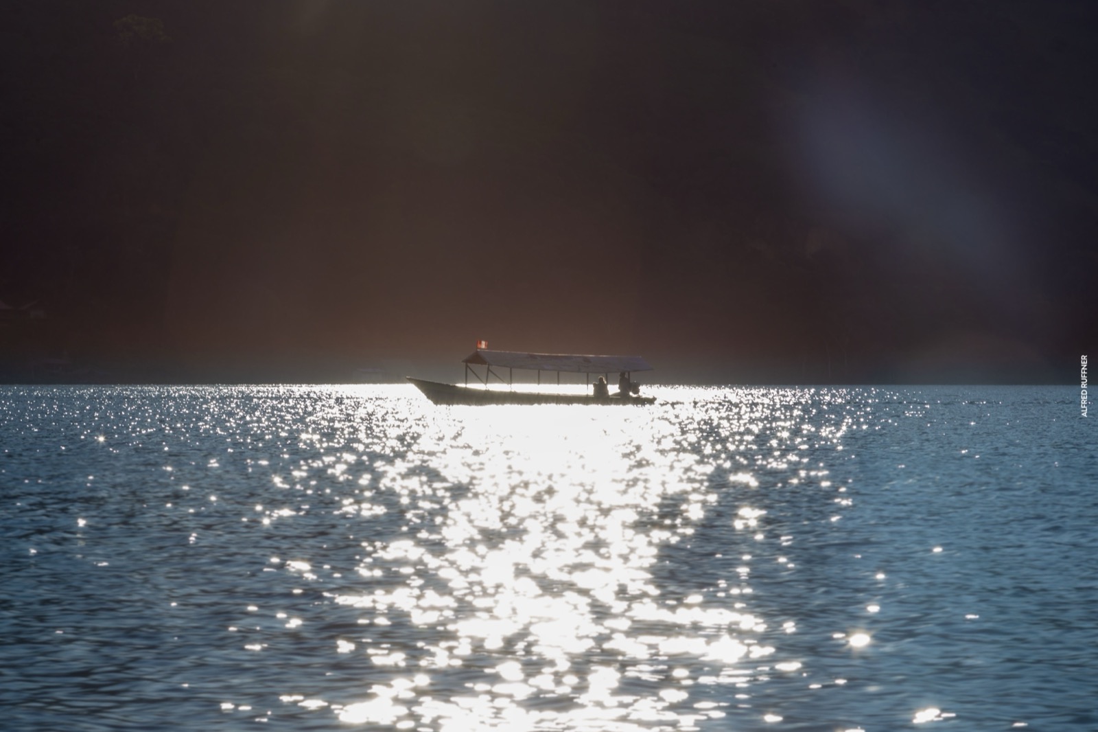 Boat on lake with dramatic backlight