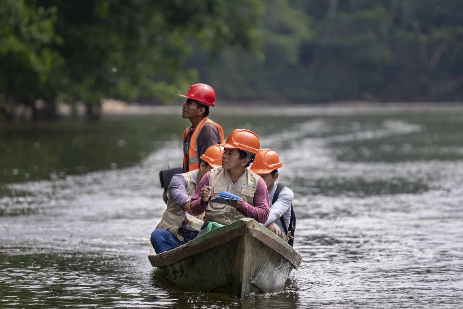 Workers in canoe on river