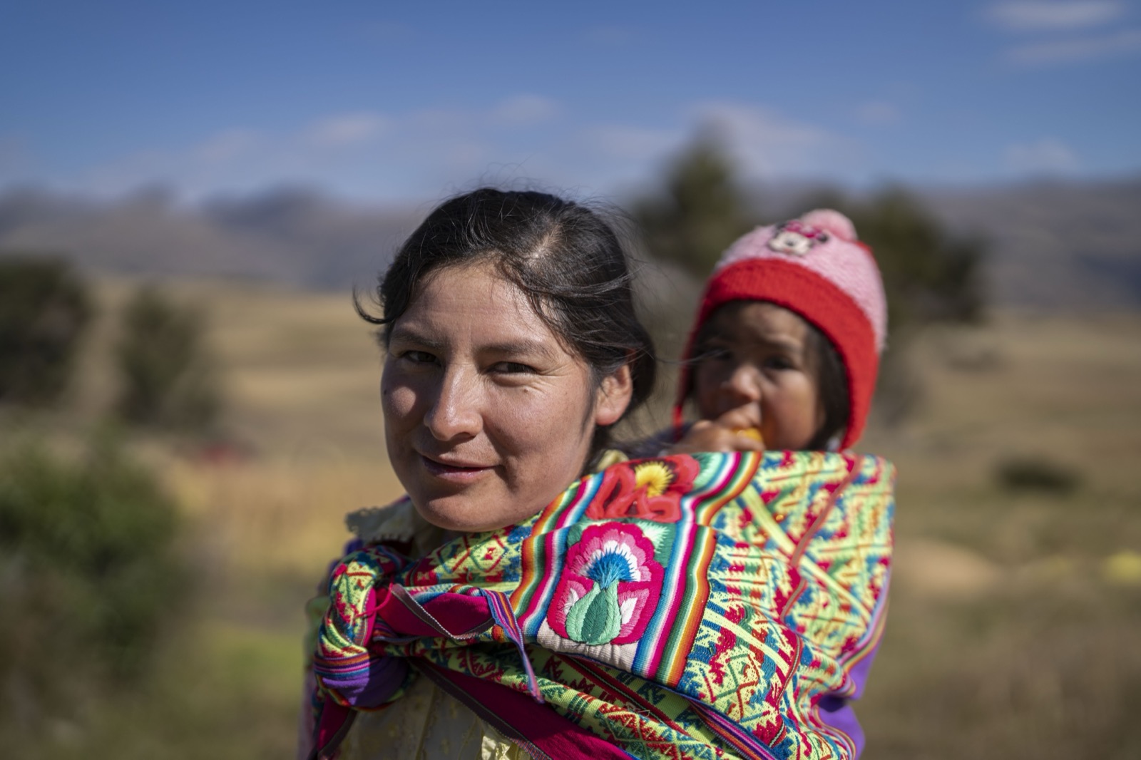Andean mother carrying baby in colorful blanket