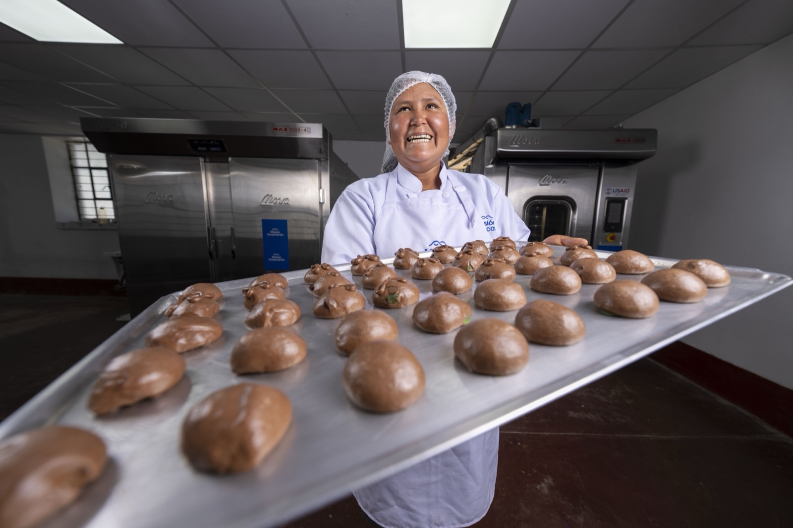 Baker with bread tray USAID project